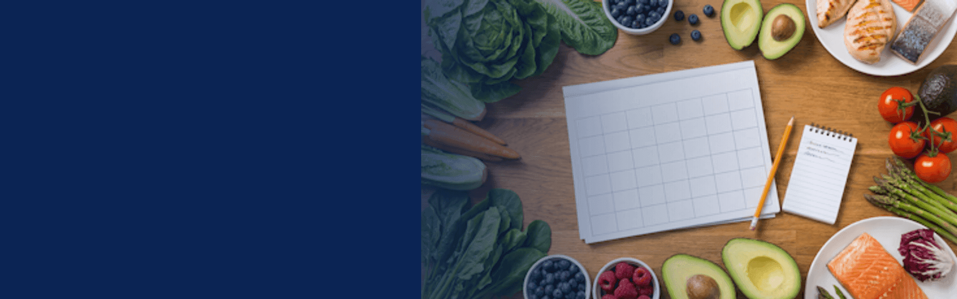 Meal planning — a calendar surrounded by fresh vegetables, salmon, avocado, and berries
